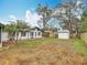 Spacious backyard featuring a well-maintained lawn, shed, and a view of the home's exterior with a sunroom at 610 Moonpenny Cir, Port Orange, FL 32127