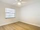 Bedroom featuring laminate flooring, a large window, white walls and a ceiling fan at 610 Moonpenny Cir, Port Orange, FL 32127