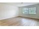 Bedroom featuring laminate flooring, a large window, white walls and baseboard at 610 Moonpenny Cir, Port Orange, FL 32127