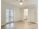 Bright bedroom with white walls, light wood flooring, ceiling fan and French doors leading outside at 610 Moonpenny Cir, Port Orange, FL 32127