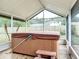 Covered hot tub in the screened patio, providing a private outdoor spa experience with views of the surrounding landscape at 610 Moonpenny Cir, Port Orange, FL 32127