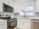 Modern kitchen featuring stainless steel appliances, gray backsplash, and white cabinets at 610 Moonpenny Cir, Port Orange, FL 32127