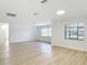 Open living room showcasing laminate flooring, multiple windows for natural light, and white walls at 610 Moonpenny Cir, Port Orange, FL 32127