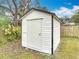 Exterior view of a white storage shed in the backyard, offering ample space for storing tools and equipment at 610 Moonpenny Cir, Port Orange, FL 32127