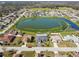 Aerial view of homes surrounding a picturesque lake, creating a serene neighborhood setting at 8867 Pebblebrooke Dr, Lakeland, FL 33810