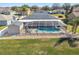 Aerial shot of a home with a screened-in pool, solar panels, and a well-maintained lawn at 8867 Pebblebrooke Dr, Lakeland, FL 33810