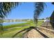 Scenic backyard view with a tranquil lake, rock landscaping, and lush greenery at 8867 Pebblebrooke Dr, Lakeland, FL 33810