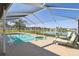 A screened-in pool and hot tub are located next to a lake, offering outdoor enjoyment on a sunny day at 8867 Pebblebrooke Dr, Lakeland, FL 33810