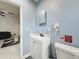 Bathroom featuring a modern vanity, toilet, and view of the main living area at 3911 Auburndale Ave, Orlando, FL 32839