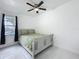 Bright bedroom with a comfortable bed, ceiling fan, and natural light from the window at 3911 Auburndale Ave, Orlando, FL 32839