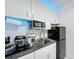 Bright kitchen featuring granite counters, stainless steel microwave, and white cabinets with blue lighting at 3911 Auburndale Ave, Orlando, FL 32839