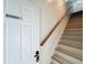 Staircase featuring a wooden handrail and secure door entry at 3911 Auburndale Ave, Orlando, FL 32839