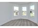Bright bedroom featuring neutral carpet, fresh white paint, and three large windows at 5295 Sw 87Th Ter, Ocala, FL 34481