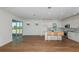 Open-concept living area with hardwood floors, kitchen, and a sliding glass door to a patio at 5295 Sw 87Th Ter, Ocala, FL 34481