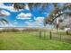 Expansive fenced backyard with lush lawn, mature trees, and a serene view of the lake at 114 Tempsford Rd, Auburndale, FL 33823