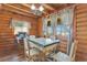 Cozy dining area with wood walls, a unique light fixture, and bright windows at 114 Tempsford Rd, Auburndale, FL 33823