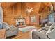 Cozy living room with a stone fireplace, wood-paneled walls, and a spiral staircase at 114 Tempsford Rd, Auburndale, FL 33823