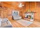 Inviting living room featuring a stone fireplace and warm, wood-paneled walls at 114 Tempsford Rd, Auburndale, FL 33823