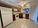 Kitchen featuring tile flooring, wooden cabinets, white appliances, granite countertops and a view of a dining area at 200 Lemon Tree Ln # A, Ormond Beach, FL 32174