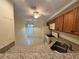 Kitchen featuring tile flooring, wooden cabinets, white appliances, granite countertops and a view of a dining area at 200 Lemon Tree Ln # A, Ormond Beach, FL 32174