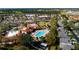 Aerial shot showcases community amenities: a sparkling pool, tennis courts, clubhouse, and lush landscaping at 2450 Shelby Ln, Clermont, FL 34711