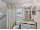 Well-lit bathroom featuring tiled shower, white vanity with granite countertop, and integrated sink at 2450 Shelby Ln, Clermont, FL 34711