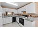 Bright kitchen with white cabinets, granite countertops, and black appliances create a clean and functional cooking space at 2450 Shelby Ln, Clermont, FL 34711