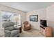 Cozy living room offering comfortable seating, a large window with blinds, and a classic entertainment center at 2450 Shelby Ln, Clermont, FL 34711