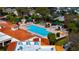 Aerial view of a community pool with lounge chairs, covered seating areas, and manicured landscaping at 2450 Shelby Ln, Clermont, FL 34711