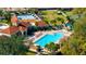 A tranquil swimming pool surrounded by palm trees and lounge chairs, adjacent to a clubhouse at 2450 Shelby Ln, Clermont, FL 34711