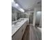 Modern bathroom with double vanity, walk-in shower, and grey tile flooring at 309 Burrowing Owl Ln, Winter Haven, FL 33880