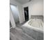 Relaxing bathroom with large soaking tub and grey tile flooring at 309 Burrowing Owl Ln, Winter Haven, FL 33880