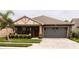 One-story home with gray siding, brown roof, and a paved driveway at 309 Burrowing Owl Ln, Winter Haven, FL 33880