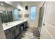 Modern bathroom boasts double sinks, a large mirror, a glass enclosed shower and decorative tile flooring at 4446 Shiva Loop, Kissimmee, FL 34746