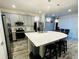 Modern kitchen features an island with stool seating, stainless steel appliances, and stylish pendant lighting at 4446 Shiva Loop, Kissimmee, FL 34746