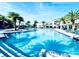 Large community pool with sun loungers, palm trees, and a play area for children at 4446 Shiva Loop, Kissimmee, FL 34746