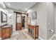 Bathroom featuring barn door entry, wood-look floors, stone shower, and wooden vanity with glass doors at 506 Parrott Rd, Auburndale, FL 33823