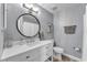 Beautiful bathroom featuring a modern vanity with white marble countertops and a large round mirror at 506 Parrott Rd, Auburndale, FL 33823