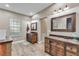 Spacious bathroom with wooden vanities, decorative mirrors, and wood-look flooring at 506 Parrott Rd, Auburndale, FL 33823