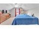 Bright bedroom features a ceiling fan, dresser, and window with red curtains at 506 Parrott Rd, Auburndale, FL 33823