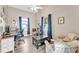 Bright bedroom with vaulted ceilings, modern ceiling fan, desk, and two upholstered arm chairs at 506 Parrott Rd, Auburndale, FL 33823