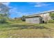 Exterior of a metal storage building featuring an open grassy field at 506 Parrott Rd, Auburndale, FL 33823