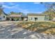 Back exterior view showcases the home's spacious yard and a covered patio at 506 Parrott Rd, Auburndale, FL 33823