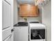 Laundry room featuring a white washer and dryer, overhead cabinets, and a clean, functional design at 506 Parrott Rd, Auburndale, FL 33823