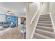 View from the stairs looking into a blue living room open to the dining area at 506 Parrott Rd, Auburndale, FL 33823