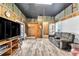 Cozy living room with wood-look floors, TV, sliding door, and rustic wood paneled walls at 506 Parrott Rd, Auburndale, FL 33823