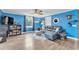 Bright living room with blue walls, wood floors, and a comfortable seating area at 506 Parrott Rd, Auburndale, FL 33823