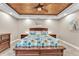 Beautiful main bedroom featuring a decorative wood plank ceiling, carpet floors, a king bed, and side tables at 506 Parrott Rd, Auburndale, FL 33823