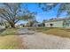 Expansive property showcasing buildings, with a large grassy lawn and gravel driveway at 506 Parrott Rd, Auburndale, FL 33823