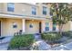 Charming two-story townhome featuring a covered porch, lush landscaping, and a welcoming entrance at 5409 Limestone Ln, Lakeland, FL 33809